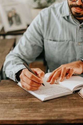 ノートにペンで書き留める手元